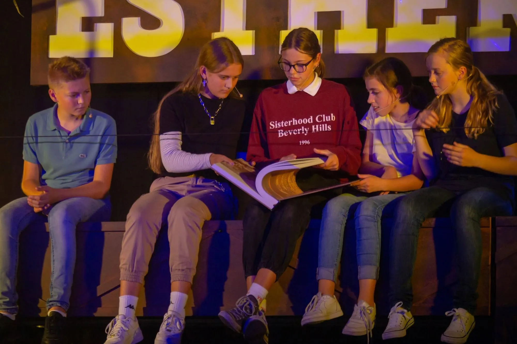 Jonge spelers lezen samen het script op het decor van Esther